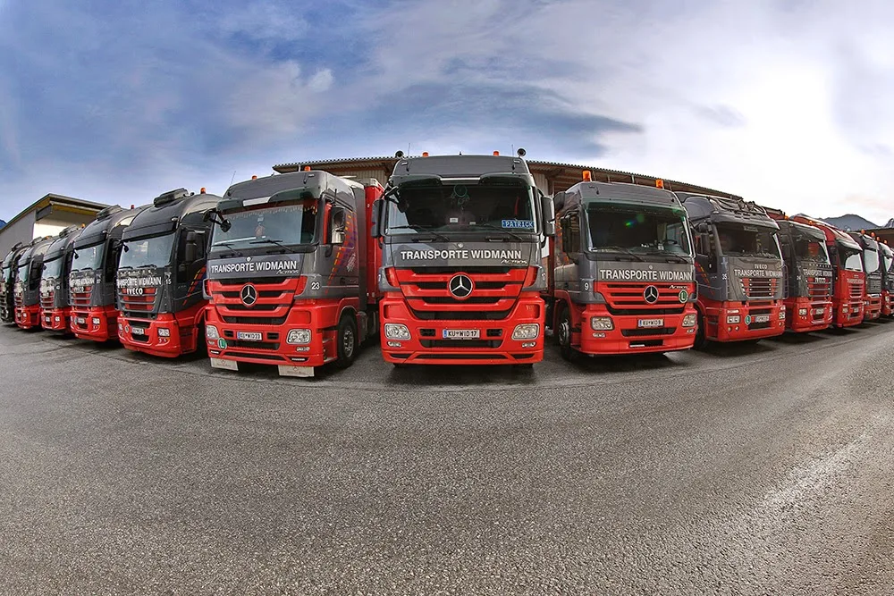 Rote und graue Lastwagen am Betriebshof von Transporte Widmann