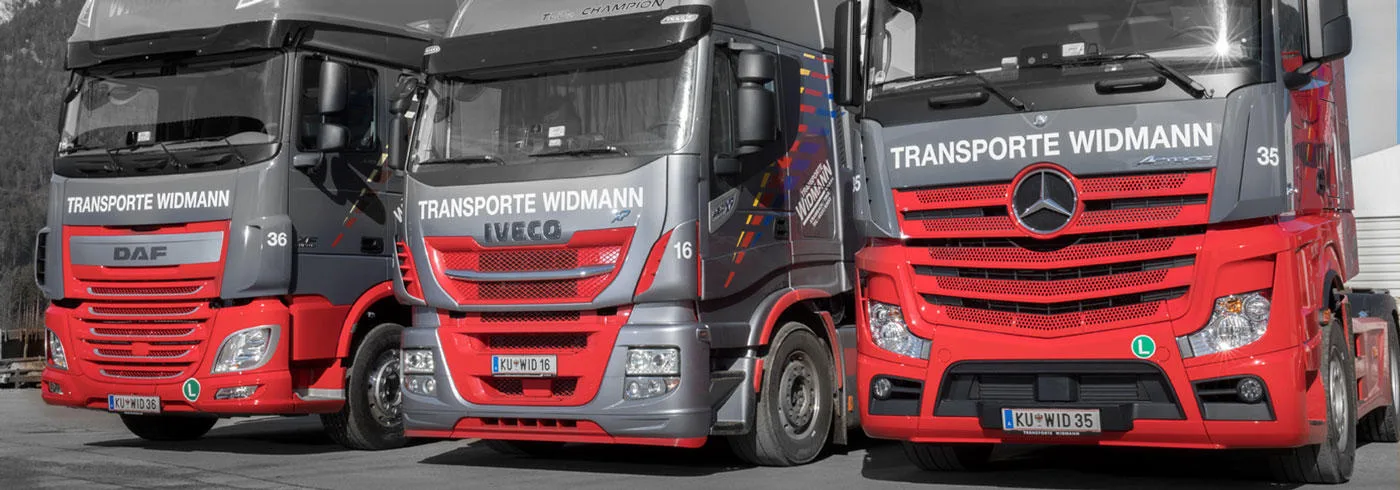 Drei beschriftete Lastwagen von Transporte Widmann