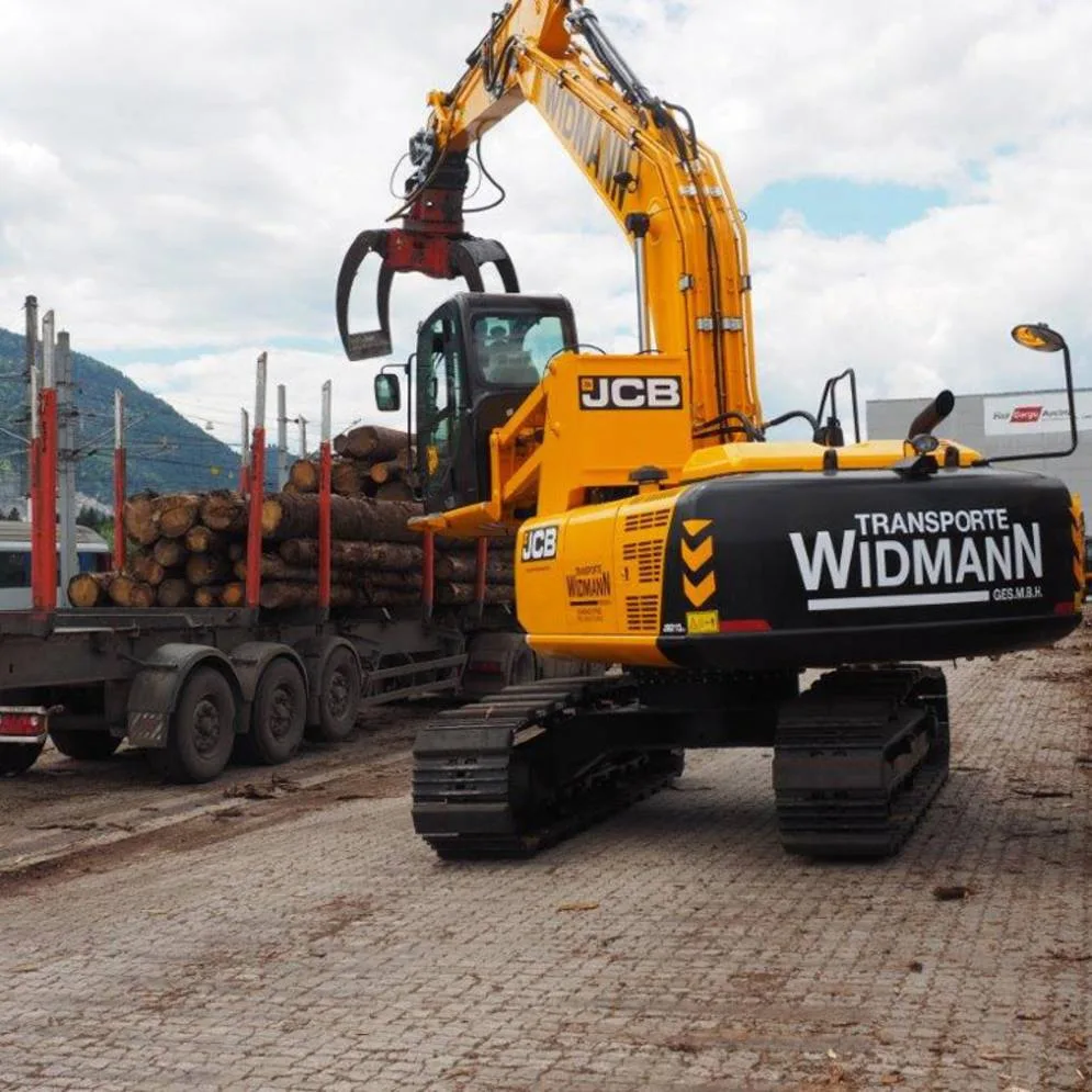 Beschrifteter Kettenbagger beim Umschlag von Holz
